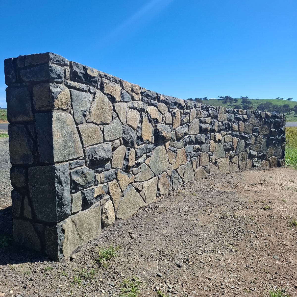 Nimmitabel basalt retaining wall with raked mortar joints, built by Homestead Stonework Canberra